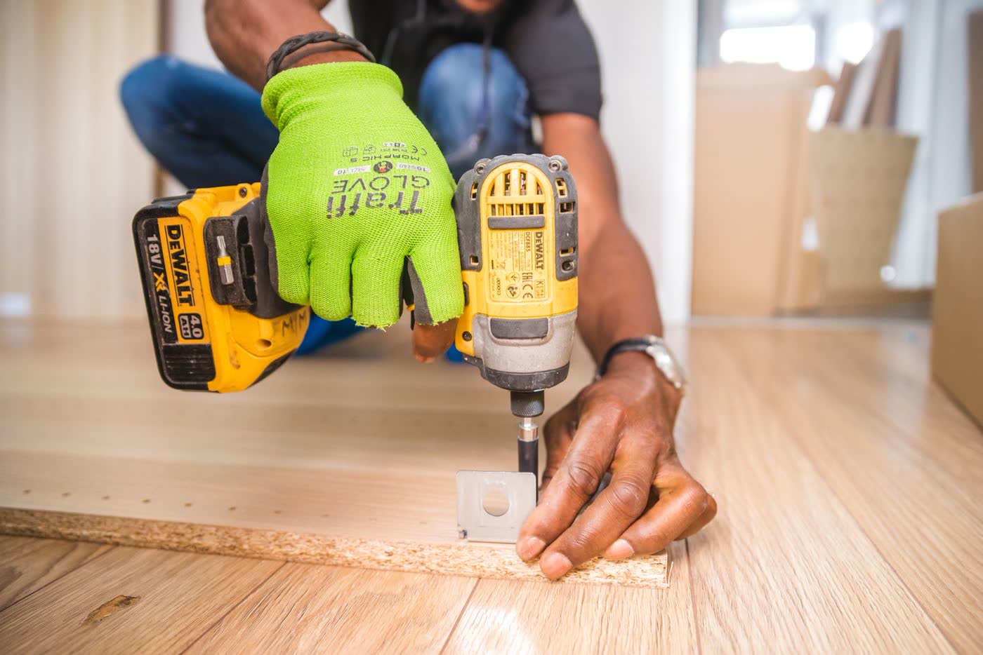 Hands using a power drill on a job site